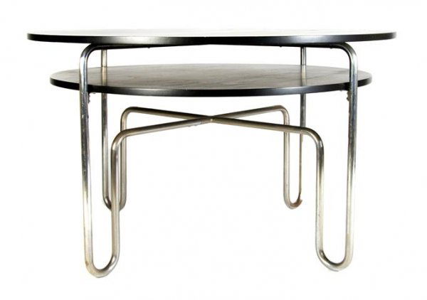 A Laminate and Tubular Steel Breakfast Table, in the Ma: A Laminate and Tubular Steel Breakfast Table, in the Manner of Gilbert Rohde, second half 20th century, the circular top over a conforming, slightly smaller medial shelf joined by bent tubular support
