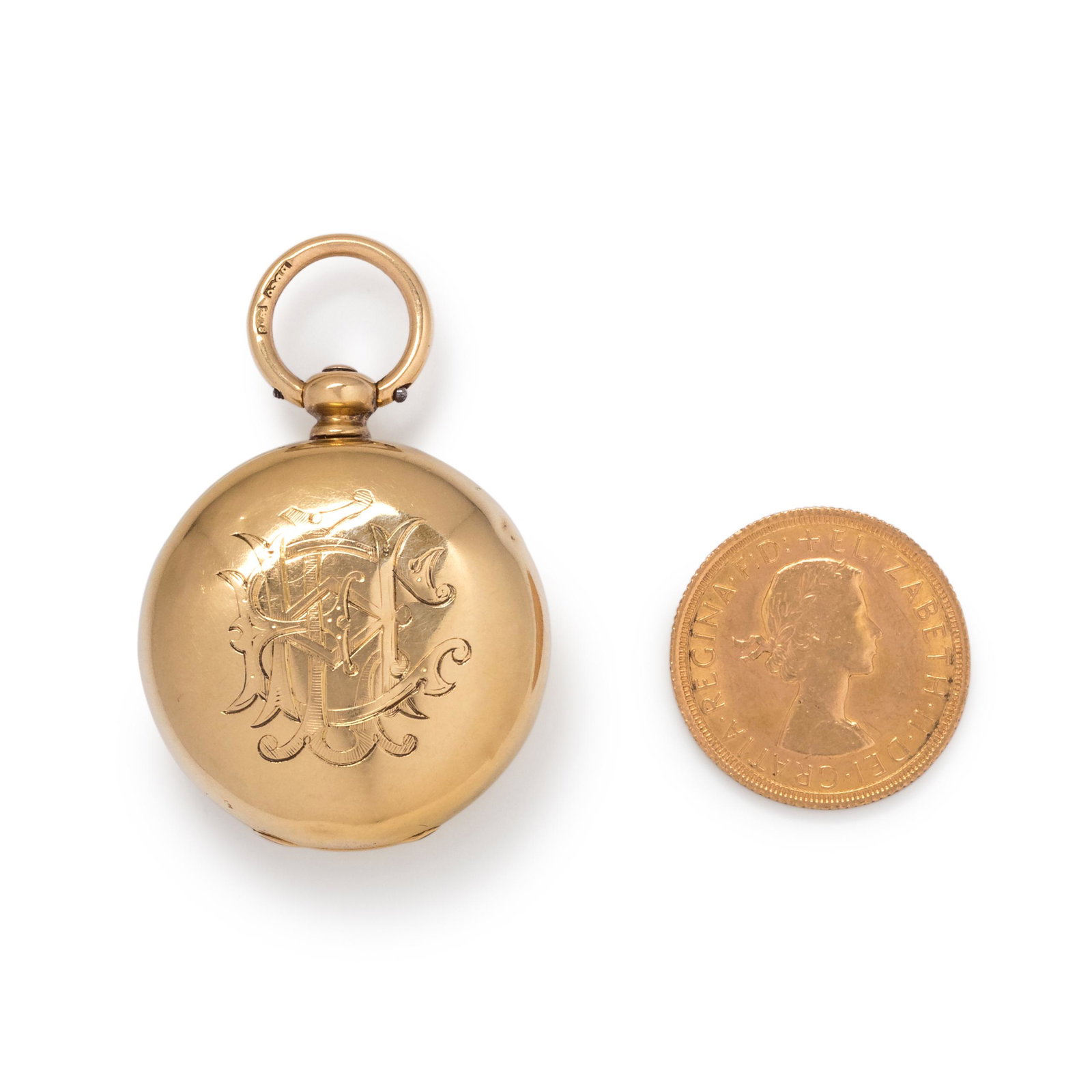 BRITISH, ANTIQUE, 18K YELLOW GOLD COIN DISPENSER: BRITISH, ANTIQUE, 18K YELLOW GOLD COIN DISPENSER 30.00 mm case diameter, the inside with spring loaded coin dispenser containing one British Sovereign coin, dated 1967, the case with monogram engravin