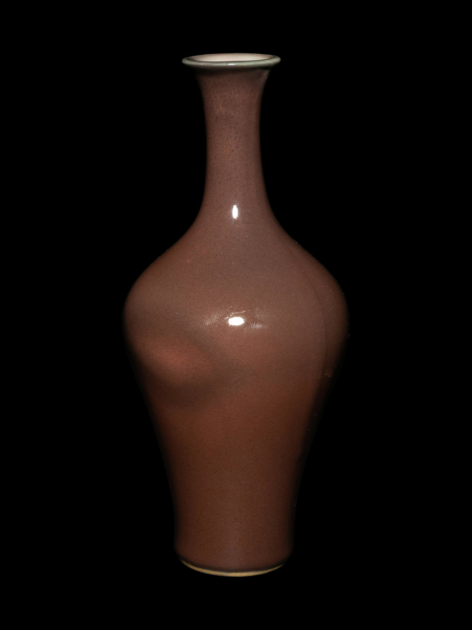 A Sang-de-Boeuf Porcelain Bottle Vase: A Sang-de-Boeuf Porcelain Bottle Vase 18TH CENTURY the pear shaped body with rounded shoulders rising to a narrow neck terminating in a delicate slightly everted mouth rim, all covered to the exterior