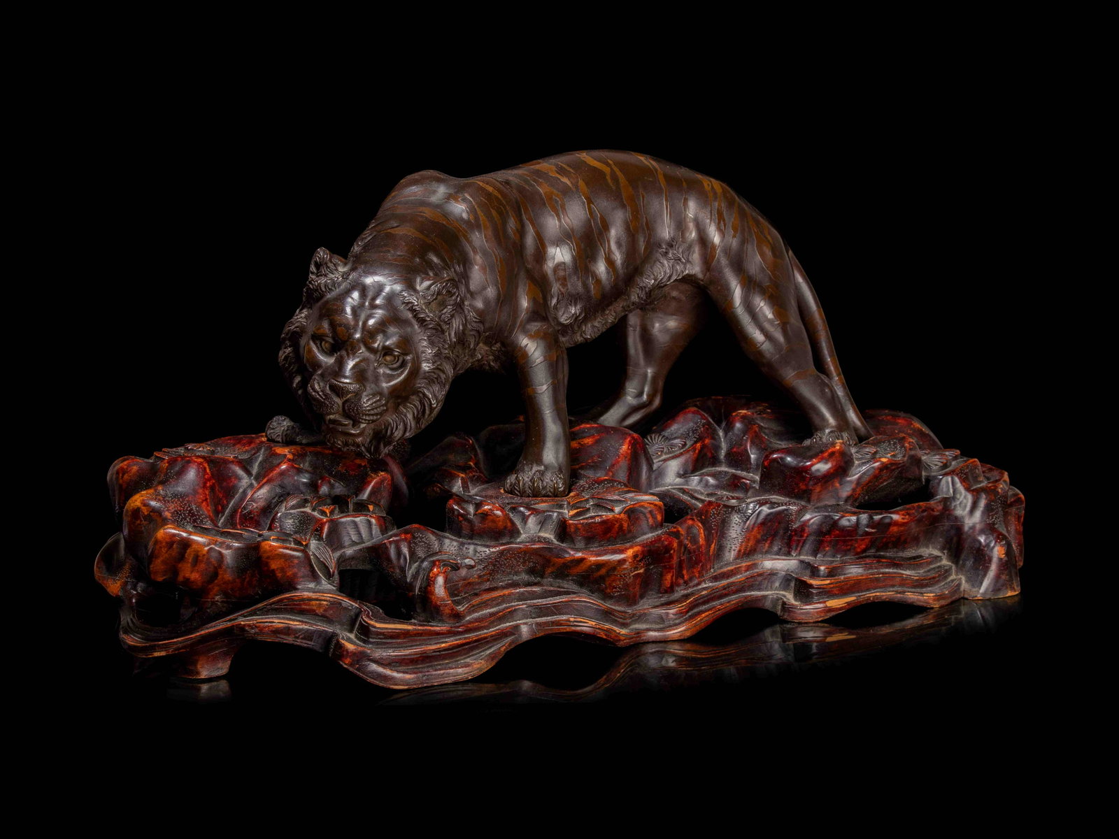 A Bronze Okimono of A Tiger: A Bronze Okimono of A Tiger BY SEIKOKU, MEIJI PERIOD. LATE 19TH/EARLY 20TH CENTURY naturalistically cast to show a waking tiger walking on a detachable hardwood base, carved in the form of rockery, th
