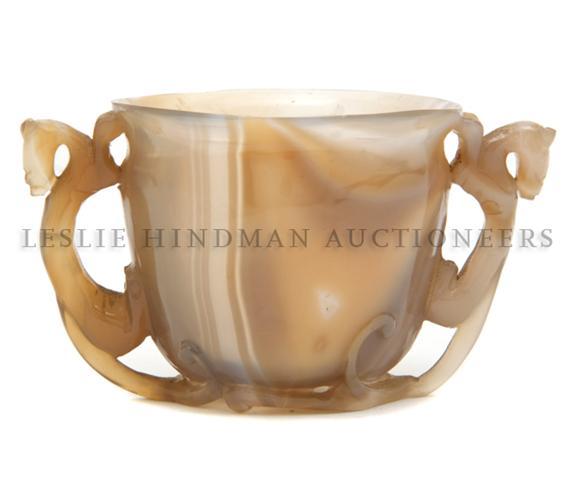 A Chinese Agate Cup Height 2 3/8 inches.: A Chinese Agate Cup the tapering cup with flared rim having twin animalistic handles. Height 2 3/8 inches.