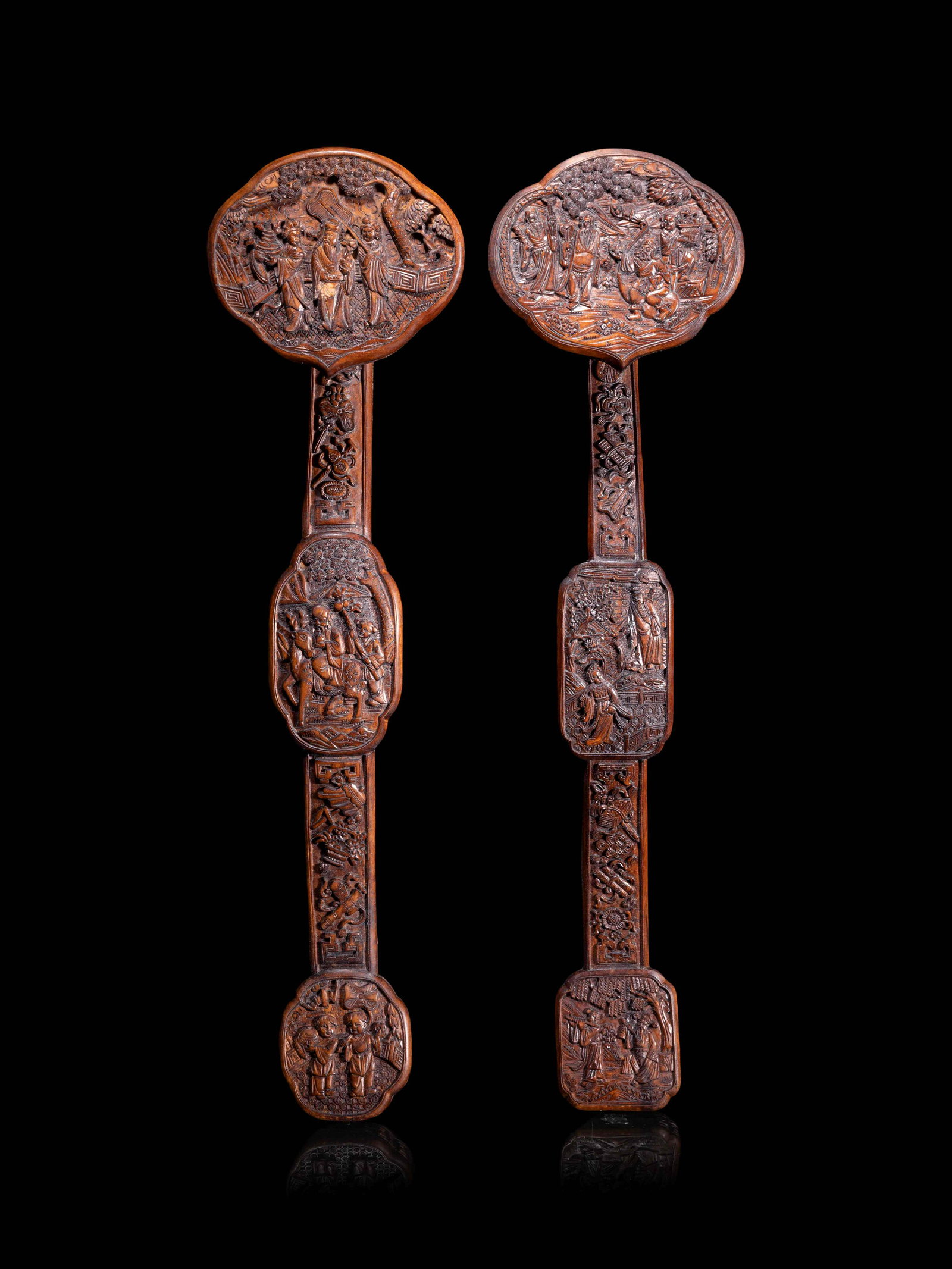 Two Chinese Carved Hardwood Ruyi Scepters: Two Chinese Carved Hardwood Ruyi Scepters each carved in low relief with various figures. Length of each 16 5/8 in., 42.4 cm.