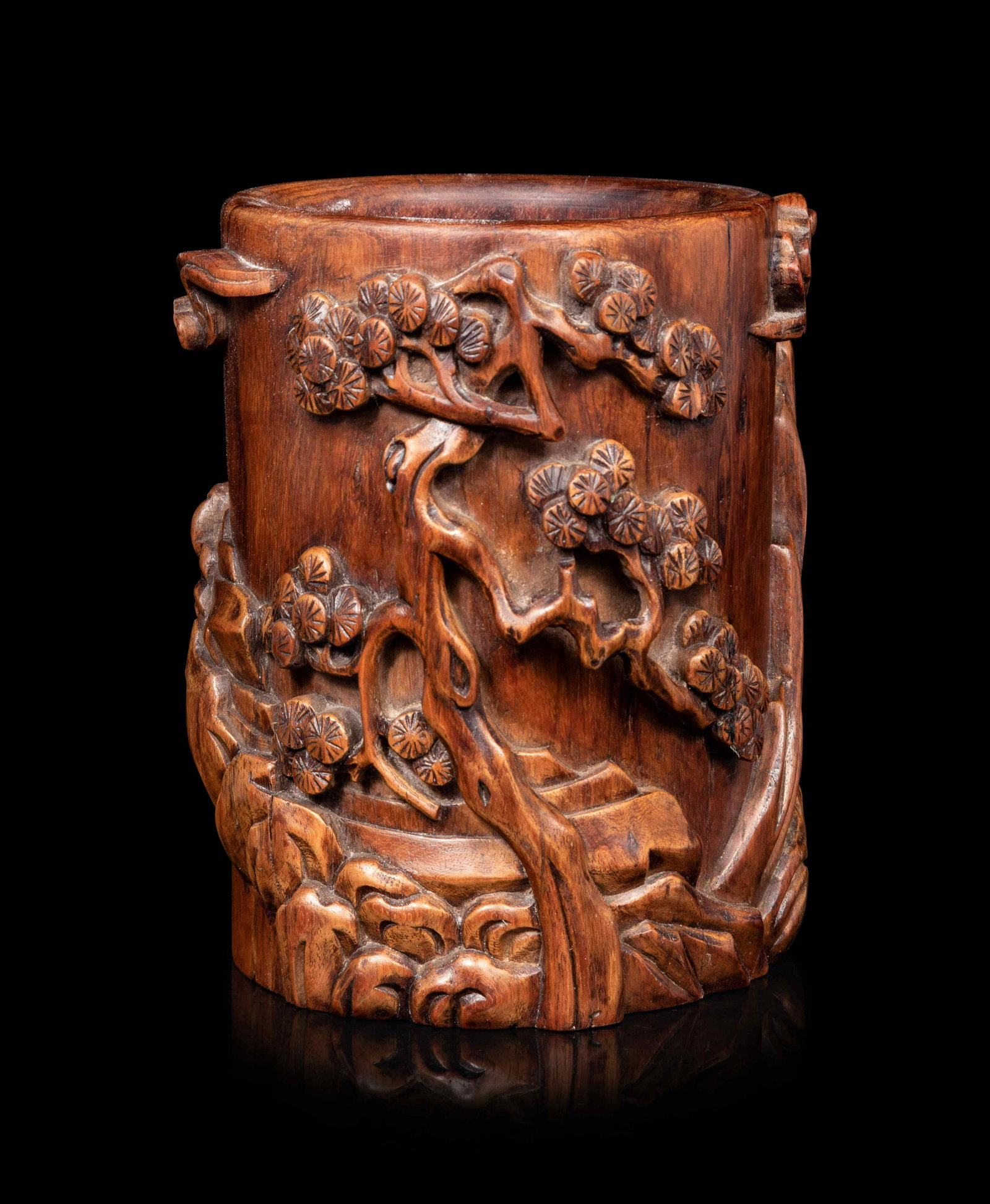 A Chinese Huagnhuali Brushpot, Bitong: A Chinese Huagnhuali Brushpot, Bitong carved in high relief with pines and rockery. Height 7 1/4 in., 18.4 cm.