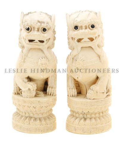 A Pair of Chinese Carved Ivory Fu Dogs, Height 5 3: A Pair of Chinese Carved Ivory Fu Dogs, the seated dogs with heads slightly turned, one with a pup and one with an embroidered ball under it's paw, each raised upon a circular double lotus form base.