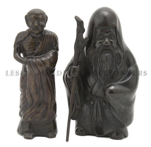 A Group of Two Asian Bronze Figures, Height of fir: A Group of Two Asian Bronze Figures, the first depicting a man with a staff and the second a man in a cloak. Height of first 9 1/4 inches. Property from the Estate of Mr. Melvin Bullard, Chicago, Illi
