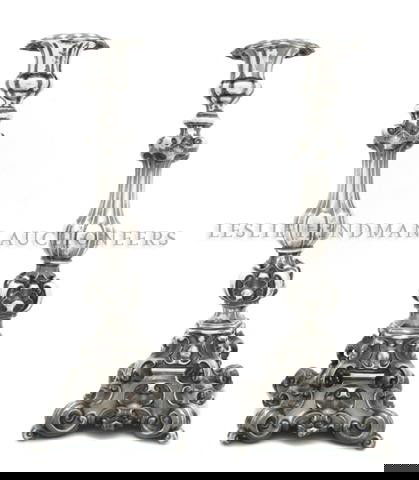 A Pair of Continental Silver Candlesticks, Height: A Pair of Continental Silver Candlesticks, of baluster from, having shell and scrolling decoration throughout, raised on four scrolled toes; approximate total weight 29.16 ozt. Height 13 3/8 inches.