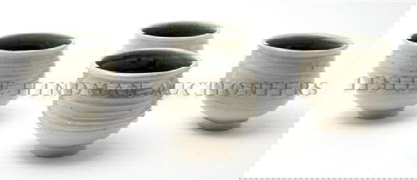 A Set of Twenty Porcelain Cups, Don Reitz (b. 192: A Set of Twenty Porcelain Cups, Don Reitz (b. 1929), having green glazed interiors with white partially iridescent exterior glaze with circular foot rings, signed Reitz on base. Height 3 1/2 inches.