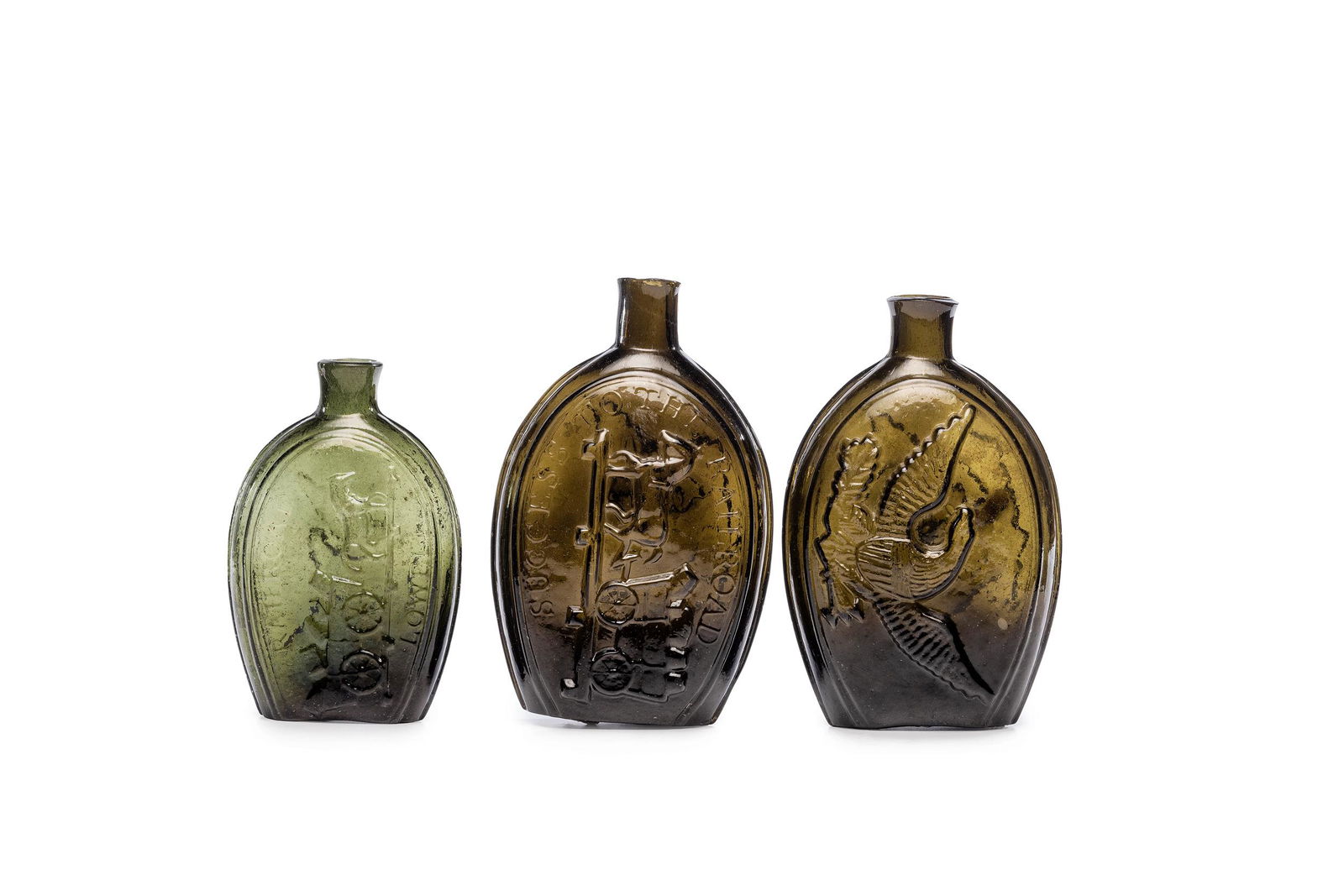 Three Mold-Blown Glass Flasks in Olive: Three Mold-Blown Glass Flasks in Olive American, Circa 1824-1840 one having an eagle with a shield, a bundle of arrows and an olive branch, and the reverse with a horse-drawn railroad car and text Suc