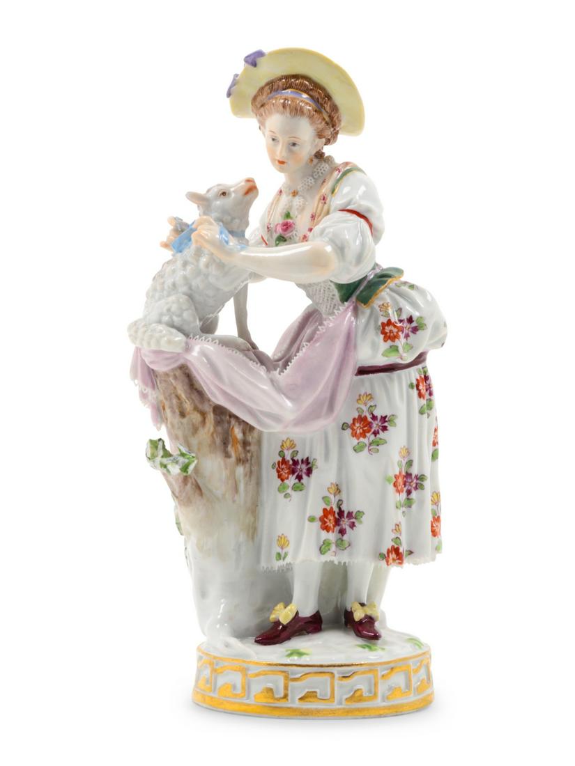 A Meissen Porcelain Figural Group: A Meissen Porcelain Figural Group Late 19th/Early 20th Century depicting a shepherdess with a lamb, bearing crossed swords in underglaze blue, further inscribed with impressed numbers and marks to the