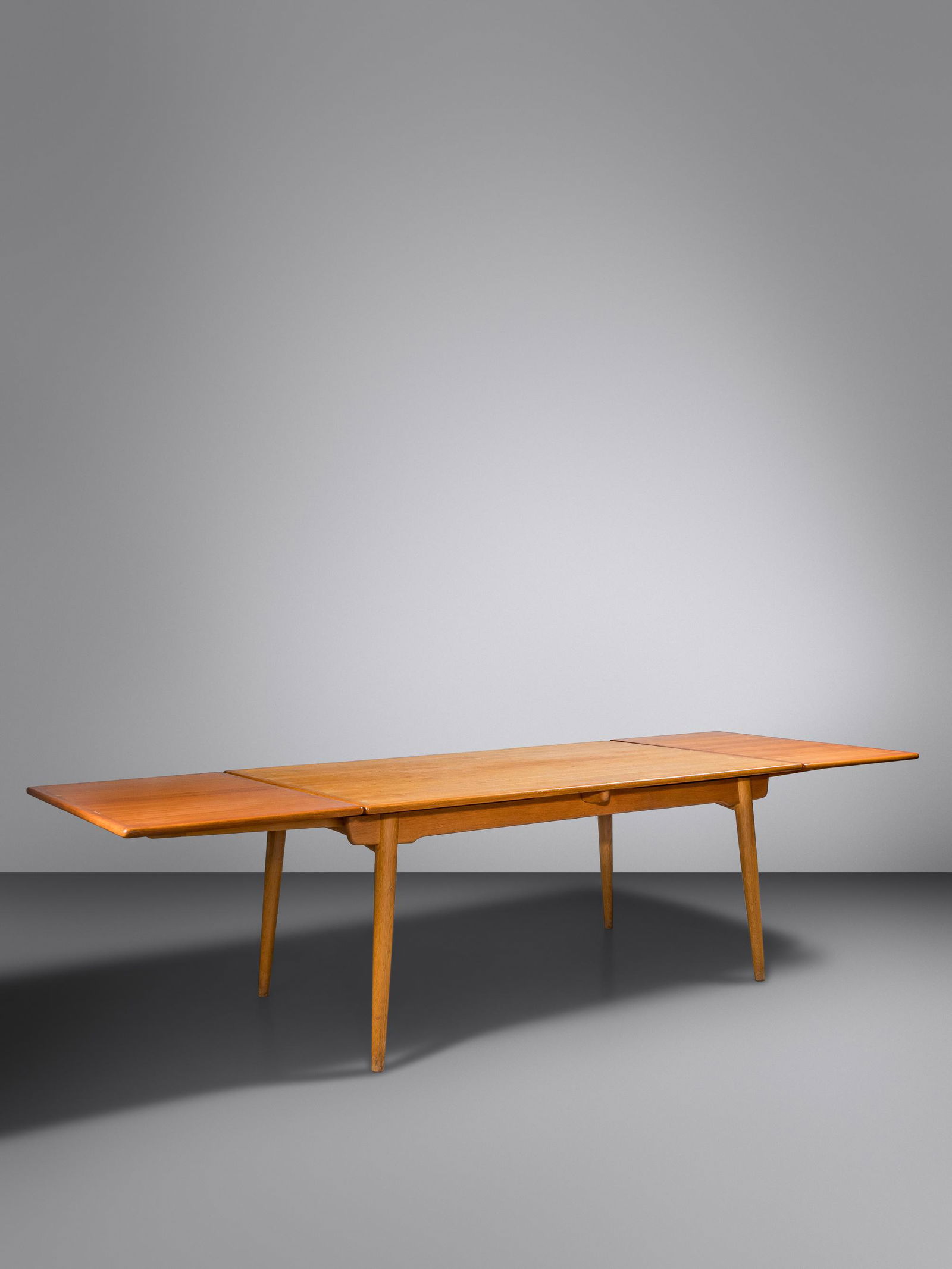 Hans J. Wegner (Danish, 1914-2007) Dining Table with: Hans J. Wegner (Danish, 1914-2007) Dining Table with Leaves, model AT312 Andreas Tuck, Denmark teak, beech manufacturer's brand to base H 28 1/4 x W 110 x D 39 1/4 inches, fully extended