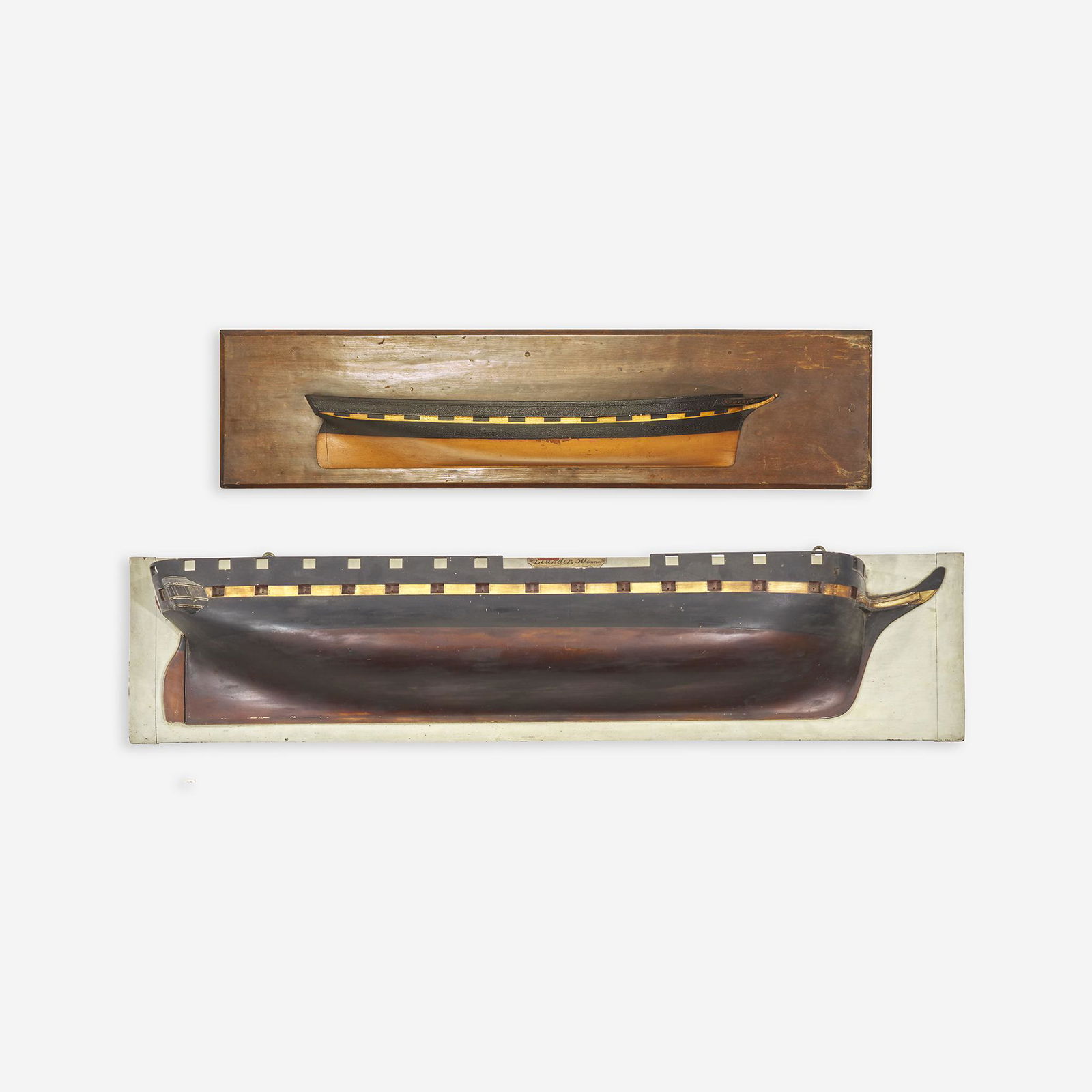 Two carved and painted half hull ship models late: Two carved and painted half hull ship models late 19th/early 20th century The larger example depicting the HMS Leander (1813-1830), accompanied by a hand-drawn scale plan of the Leander hull, listing