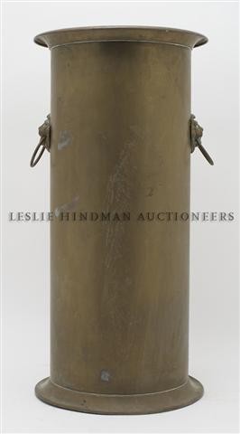 A Brass Umbrella Stand, Height 21 1/2 inches.: A Brass Umbrella Stand, of cylindrical form, further mounted with lion masks and ring handles. Height 21 1/2 inches.