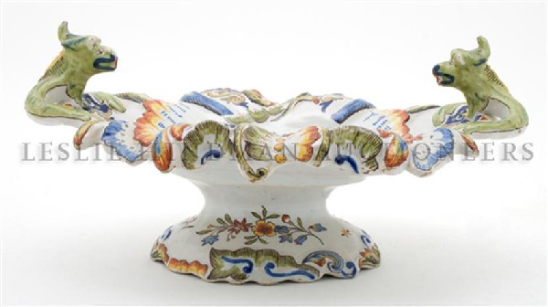A French Faience Bowl, Rouen, Height 7 x width 14 1/4 i: A French Faience Bowl, Rouen, of oval form, having a scalloped rim and dragon handles with allover scrolling and foliate decoration, raised on an oval foot. Height 7 x width 14 1/4 inches.