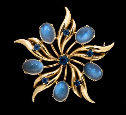 A 14 Karat Yellow Gold, Moonstone and Synthetic Sapphir: A 14 Karat Yellow Gold, Moonstone and Synthetic Sapphire Brooch, measuring approximately 38.00 mm in diameter. Stamp: 14K. 6.90 dwts. Property from the Estate of Marjorie Jeanne Wiley, Evanston, Illin
