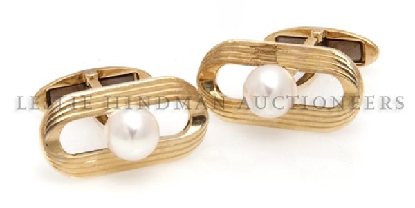 A Pair of 14 Karat Yellow Gold and Cultured Pearl Cuffl: A Pair of 14 Karat Yellow Gold and Cultured Pearl Cufflinks, Mikimoto, containing two pearls measuring approximately 7.00 mm in diameter. Stamp: (Mikimoto maker's mark). 6.95 dwts. Property from the E