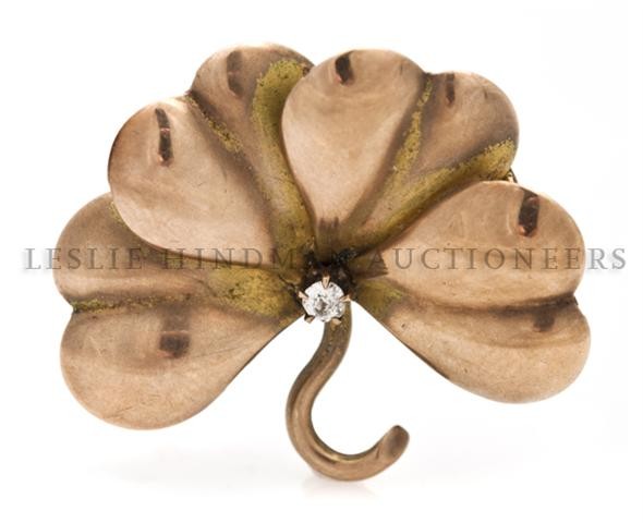 A 14 Karat Rose Gold and Diamond Brooch in a Clover Lea: A 14 Karat Rose Gold and Diamond Brooch in a Clover Leaf Motif, containing old mine cut diamond weighing approximately 0.03 carat. 1.85 dwts. Property from the Estate of Mrs. John H. (Len W.) Perkins,