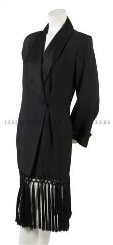 An Yves Saint Laurent Black 'Le Smoking' Jacket,: An Yves Saint Laurent Black 'Le Smoking' Jacket, 1980s, with three-quarter bell sleeves, satin cuffs and shawl collar, double breasted closure, tassel fringe at hem, fully lined. Labeled: Yves Saint L
