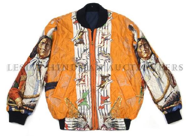 An Hermes Orange Silk Scarf Bomber Jacket, Size 48: An Hermes Orange Silk Scarf Bomber Jacket, reversible to navy blue cotton, quilted silk in an American Indian motif. Labeled: Hermes Paris. Size 48.