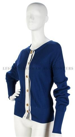 A Chanel Blue Cotton Cardigan Sweater, Size 40.: A Chanel Blue Cotton Cardigan Sweater, with gold elephant buttons atop a white grosgrain ribbon. Labeled: Chanel. Size 40. Property from the Estate of Eunice Johnson, Chicago, Illinois