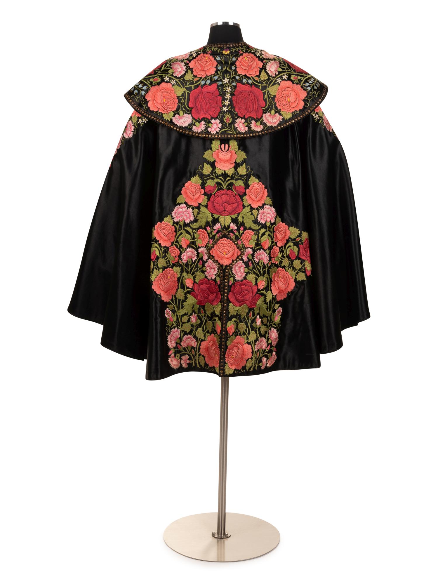 Embroidered Satin Matador Cape, 1950s: Embroidered Satin Matador Cape, 1950s This cape was updated in the mid 20th century with a jeweled strap, which allows for the cape to sit away from the neck. Black silk satin matador cape with top ca