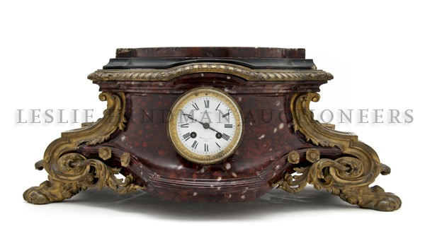 A Louis XVI Style Gilt Bronze and Marble Mantel Clo: A Louis XVI Style Gilt Bronze and Marble Mantel Clock, the shaped front cornice above a conforming case with a circular dial having Roman numerals, the case with wreath and foliate mounts throughout, 