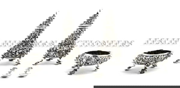 A Pair of American Sterling Silver Casters, Schof: A Pair of American Sterling Silver Casters, Schofield, having foliate repousse decoration throughout raised on paw feet, together with two associated salt cellars and salt spoons; approximate total we