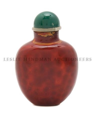 A Mottled Glass Snuff Bottle in Imitation of Realga: A Mottled Glass Snuff Bottle in Imitation of Realgar, in spade form with yellow, orange and red tones with a visible circular pattern in the glass throughout. Height of bottle 2 inches. Property of a
