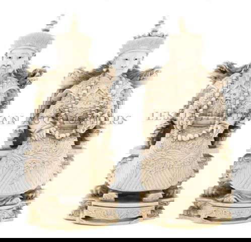 A Pair of Carved Ivory Figures of a Seated Emperor: A Pair of Carved Ivory Figures of a Seated Emperor and Empress, each figure realistically carved with embroidered robes and clutching a court necklace in their hand, raised on a carved throne chair wi