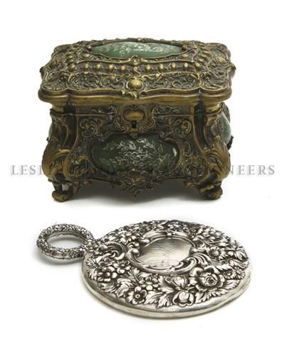 A Bronze Jewelry Casket, Height of first 5 inches.: A Bronze Jewelry Casket, having oval panels and overall foliate decoration, together with an American Silver hand mirror having overall floral decoration. Height of first 5 inches. Property from the C