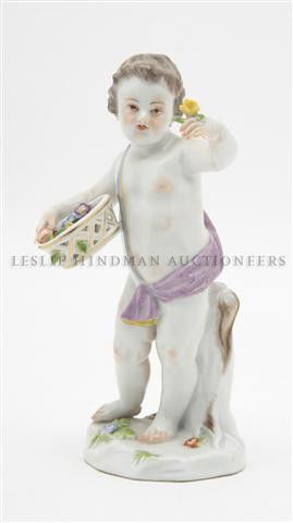 A Meissen Porcelain Figurine, Height 5 1/2 inches: A Meissen Porcelain Figurine, depicting a putto with a basket of flowers, impressed 29, incised A64, having crossed swords mark in underglaze blue. Height 5 1/2 inches.