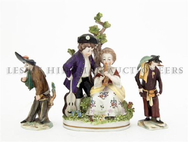A Pair of Capodimonte Porcelain Figures, Height of: A Pair of Capodimonte Porcelain Figures, depicting harlequins, together with an English porcelain figural group depicting a courting couple. Height of tallest 6 3/4 inches. Property from the Estate of