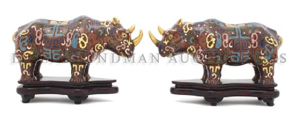 A Pair of Chinese Cloisonne Rhinoceros, Length 8 1: A Pair of Chinese Cloisonne Rhinoceros, having gilt horns and stringing throughout with polychrome enameling, raised on fitted carved wood stands. Length 8 1/4 inches. Property of a Private Collector