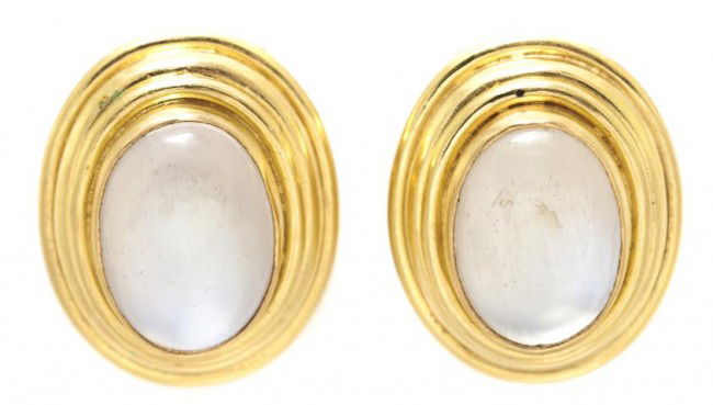 A Pair of 18 Karat Yellow Gold and Moonstone Earcl: A Pair of 18 Karat Yellow Gold and Moonstone Earclips, Elizabeth Locke, containing two oval cabochon cut moonstones measuring approximately 12.30 x 9.00 mm and backed with a mother-of-pearl layer. Sta