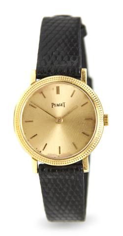 An 18 Karat Yellow Gold Wristwatch, Piaget,: An 18 Karat Yellow Gold Wristwatch, Piaget, 23.00 mm case diameter, brushed gilt dial, applied baton numerals, coin edge bezel, snap on case back, quartz movement, black lizard strap, yellow gold sign