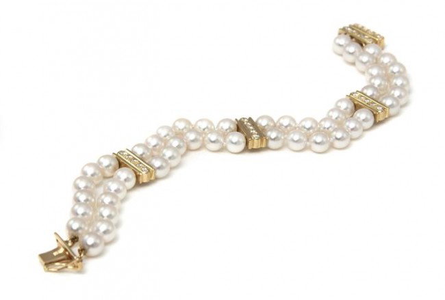 A Double Strand Cultured Pearl Bracelet, Mikimoto,: A Double Strand Cultured Pearl Bracelet, Mikimoto, containing two strands of pearls measuring approxiamtely 5.50 - 6.00 mm in diameter accented with three 18 karat yellow gold spacing bars set with 15