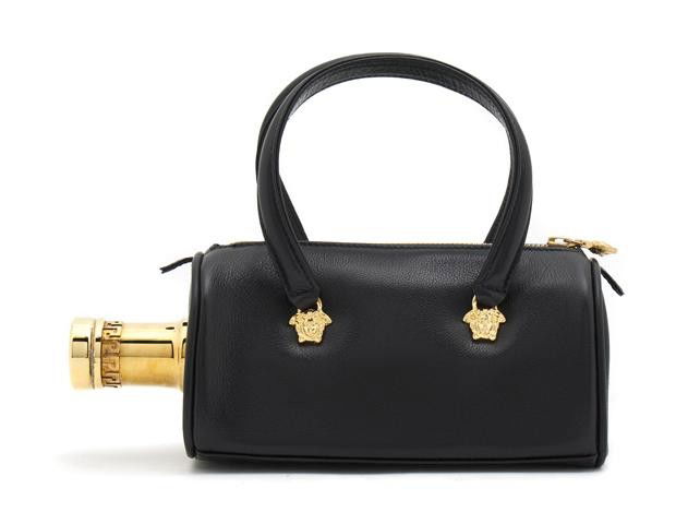 A Gianni Versace Black Leather 'Absolut Vodka' Bag: A Gianni Versace Black Leather 'Absolut Vodka' Bag, with gold Medusa heads at base of strap, bottle top at side, zipper top. Labeled: Gianni Versace. 8 x 4 1/2 inches.