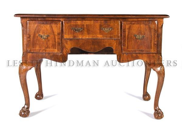A Queen Anne Walnut Lowboy, Height 29 1/2 x width 4: A Queen Anne Walnut Lowboy, the rectangular top above three short drawers, having a shaped apron at front and sides, raised on cabriole legs with carved shell decoration at knees terminating in claw a