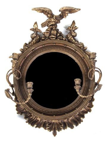 An American Federal Giltwood Bullseye Mirror, Heig: An American Federal Giltwood Bullseye Mirror, the crest with an eagle having spread wings on a naturalistic rock base flanked by dolphins over the convex plate, the frame issuing a pair of two-light c