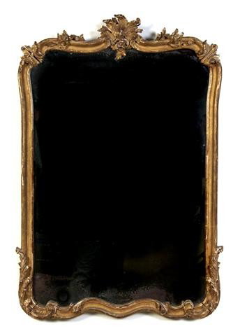 A French Rococo Revival Giltwood Mirror, Height 39: A French Rococo Revival Giltwood Mirror, of shaped rectangular form, set in a carved frame. Height 39 x width 27 inches. Property from the William H. Moore Trust, Hobe Sound, Florida