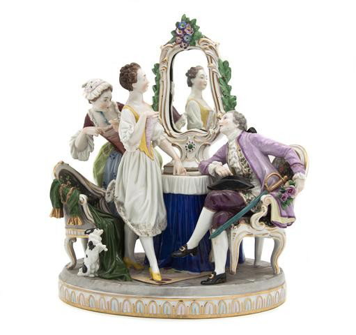 A Continental Porcelain Figural Group, Height 11 1: A Continental Porcelain Figural Group, depicting a gentleman and two ladies before a dressing table with mirror, a door at their feet. Height 11 1/8 inches. Property from a Southeast Michigan Collecto
