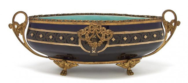 A Sarreguemines Gilt Metal Mounted Majolica Jardin: A Sarreguemines Gilt Metal Mounted Majolica Jardiniere, of flattened oval form, the cobalt reserve with scrolling gilt decoration raised on four claw feet. Length over handles 19 inches.
