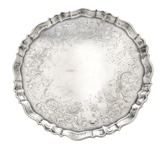 An English Silver Salver, Joseph Sanders, Diameter: An English Silver Salver, Joseph Sanders, London, 1737, having a pie crust edge with engraved decoration raised on hoof feet; approximate weight 25.4 ozt. Diameter 11 7/8 inches. Property from the Est