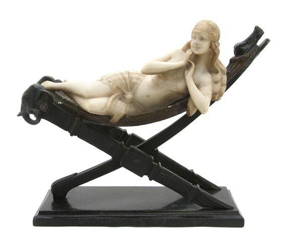 An Italian Alabaster and Bronze Figure of a Woman,: An Italian Alabaster and Bronze Figure of a Woman, early 20th century, depicting a reclining woman atop an X-form lounge, raised on a rectangular green marble base. Height 13 x width 17 inches.