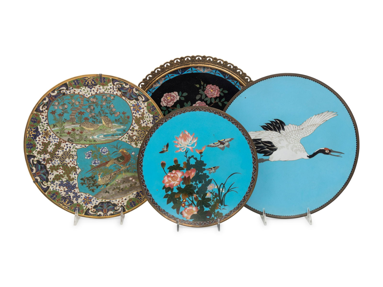 Four Japanese Cloisonné Chargers Diameter of largest 13 3/4 in., 35 cm.: Four Japanese Cloisonné Chargers comprising two blue-ground examples, the larger painted with a flying crane, the smaller showing butterflies amongst lotus; a black-ground centerpiece decorated w