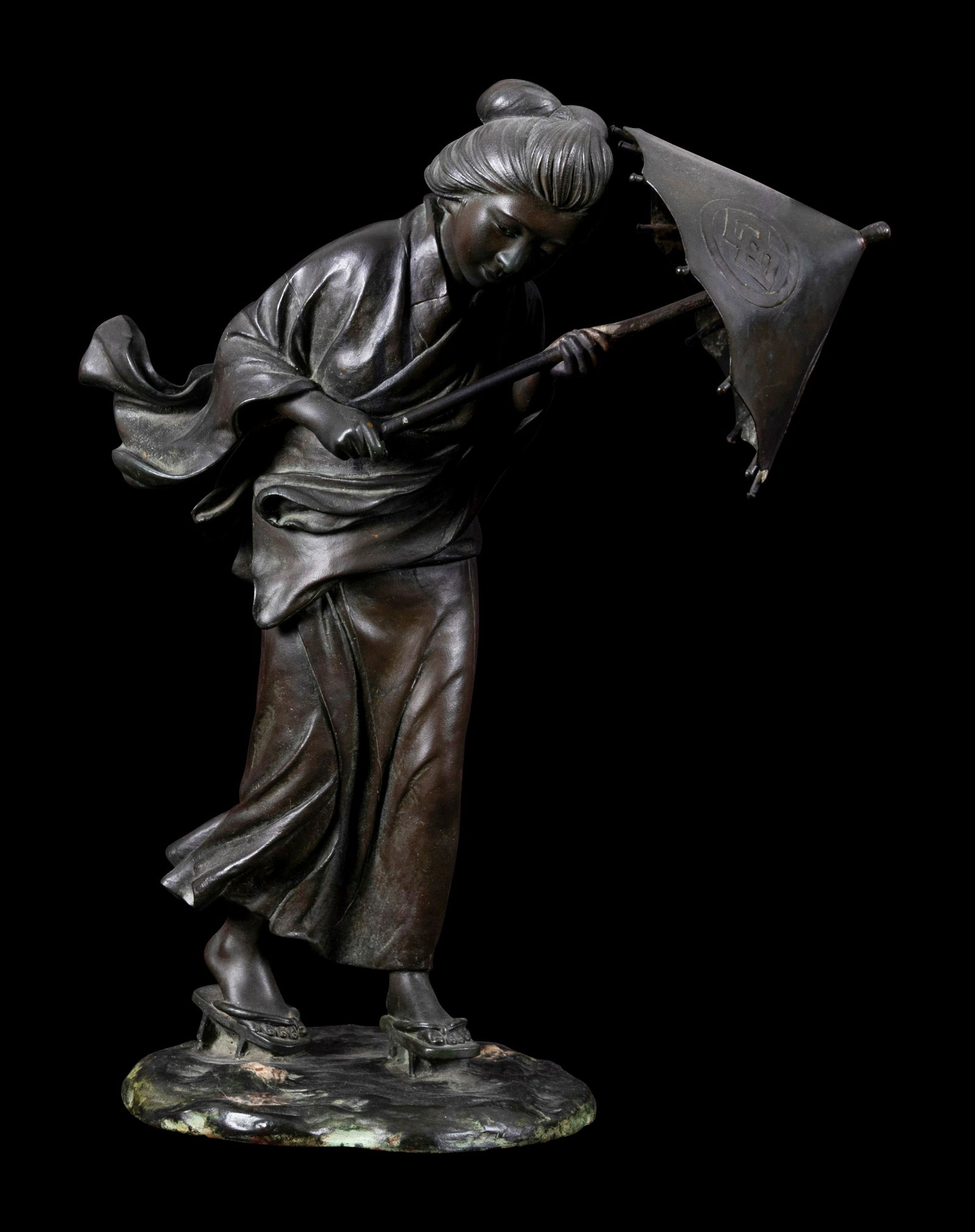 A Japanese Bronze Okimono of A Lady Height 16 x width 13 in., 40.6 x 33 cm.: A Japanese Bronze Okimono of A Lady the lady cast to show walking, holding an umbrella at front. Height 16 x width 13 in., 40.6 x 33 cm. Property from the Private Collection of Stan Guthri