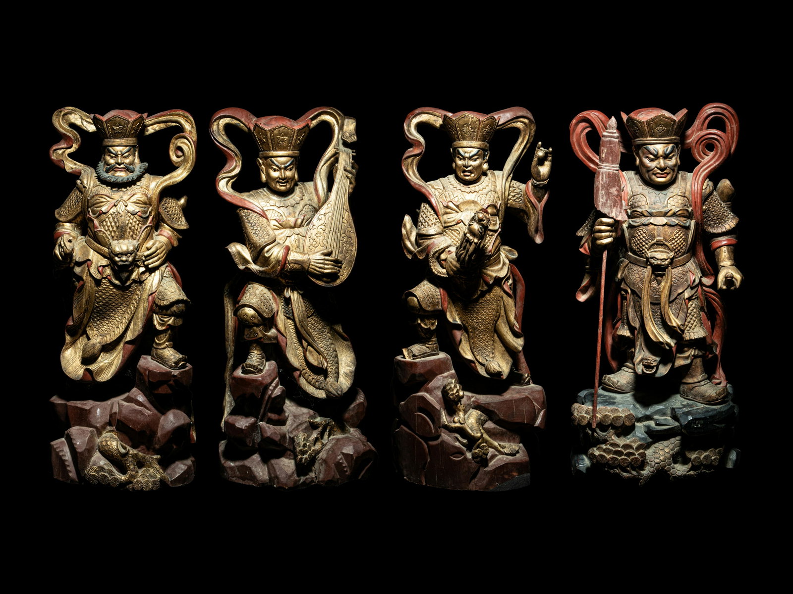 A Set of Four Gilt and Red Lacquered Wood Figures of Guardians Height 25 in., 63.5 cm.: A Set of Four Gilt and Red Lacquered Wood Figures of Guardians 金漆木雕四大天王像 each carved in a dynamic pose, wears elaborately detailed armor 