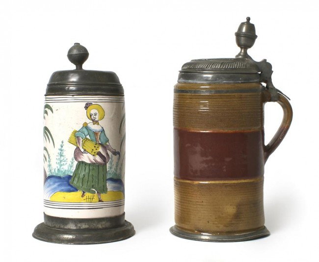 A Continental Pewter Mounted Faience Tankard, Height of: A Continental Pewter Mounted Faience Tankard, of cylindrical form, having polychrome decoration depicting a woman in rural landscape, bearing the date 1749, along with a similar stoneware example, bea
