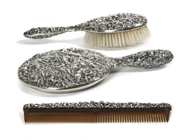 An American Sterling Three-Piece Dresser Set, Kirk & So: An American Sterling Three-Piece Dresser Set, Kirk & Son, Inc., comprising hand mirror, hairbrush and comb, each having repousse floral and foliate decoration throughout. Length of first 10 inches.