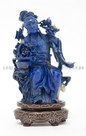 A Carved Lapis Asian Figure, Height 4 1/8 inches.: A Carved Lapis Asian Figure, depicting a maiden seated with a basket, raised on a wooden base. Height 4 1/8 inches. Property from the Collection of Robert W. McDonald, Naples, Florida