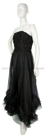 A Balenciaga Black Strapless Ballgown,: A Balenciaga Black Strapless Ballgown, 1980s, interwoven ribbon and lace bodice, flowing skirt with pleated flower-like hemline. Labeled: Balenciaga.